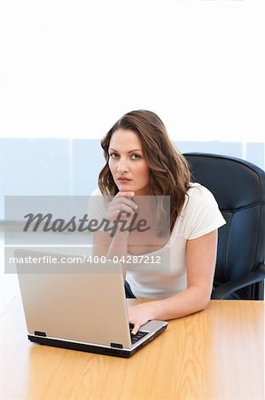 Attractive businesswoman working on laptop at a table in the office