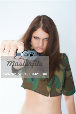 Sexy young woman with a gun isolated on white