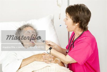 Hospital nurse uses and otoscope and tongue depressor to examine a patient.