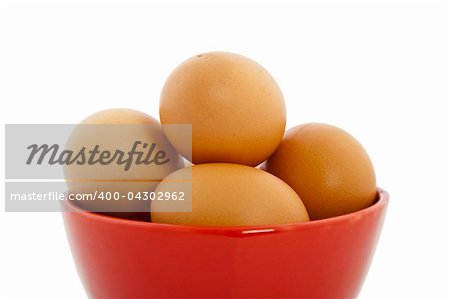 brown eggs in red bowl on white background