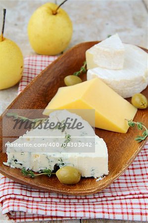Various types of cheese on a wooden cutting board