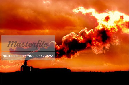 Factory belching out polution at sunset for a scene of global warming