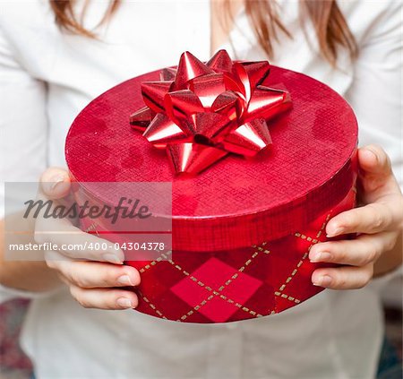 an image of red box holding in hand of young girl