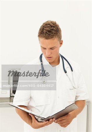 Handsome blond doctor reading results of medical test