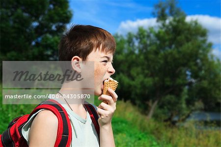 boy eats ice cream in the summer day