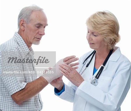 A female doctor is bandaging an elderly male patient's hand. Isolated on white.
