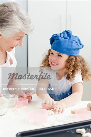 A little girl baking with her grandmother at home