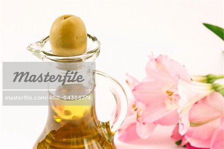 fresh olive oil in a glass bottle on a white background