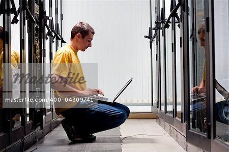 The engineer sits front equipment in datacenter