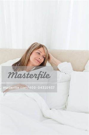 Mature woman lying down in her bed at home