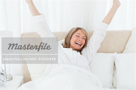 Happy woman in her bed at home