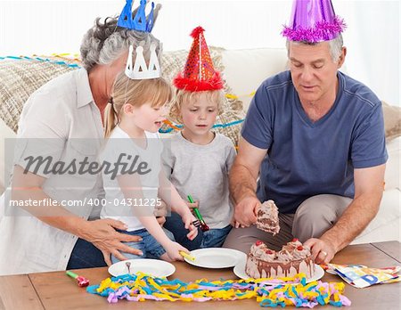 Family eating the birthday cake together at home