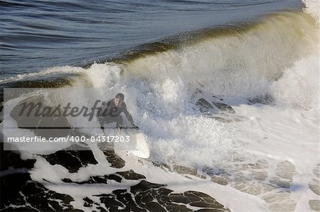 Surfer gets up on a wave. The wave twists with foam and splashes.