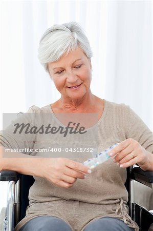 Senior in wheelchair with pills