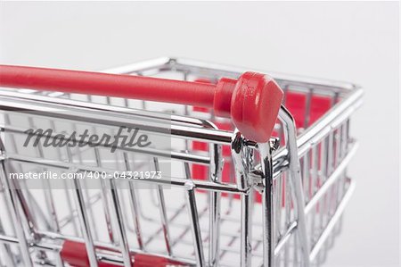 Empty shopping cart with the red handle on a white background.
