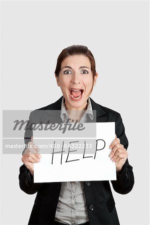 Stressed business woman imploring for help, holding a cardboard with the message "Help"