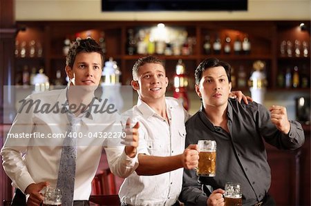 Young men with a beer watching the match in the bar