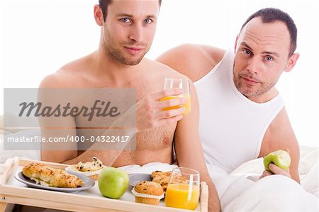 A Happy homo couple and their breakfast on a tray in bed