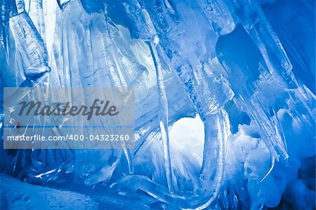 blue ice cave covered with snow and flooded with light