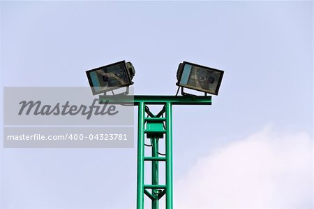 Spot light pole at stadium over sky background.