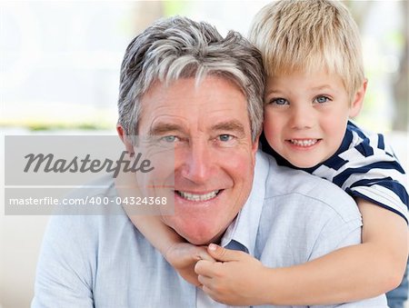 Little boy with his grandfather looking at the camera