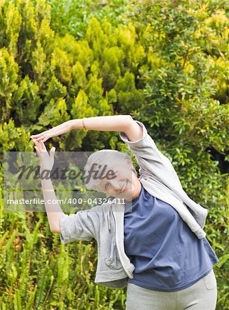 Mature woman doing her streches in the garden