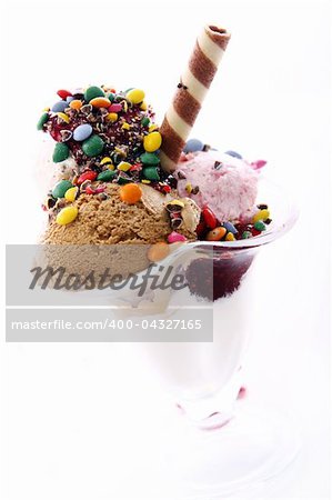 Ice cream dessert with colorful candies on white background