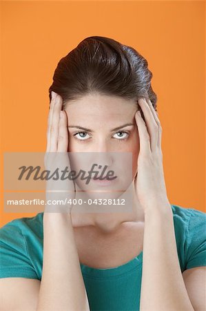 Stressed out Caucasian woman massaging her temples with fingers