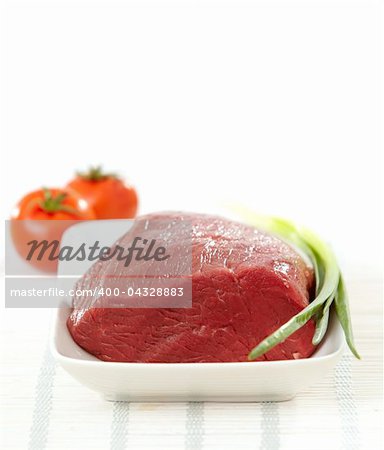 fresh raw meat on white plate on white background