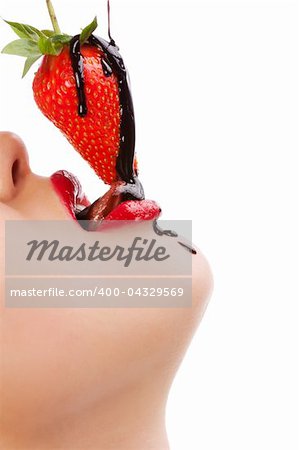 Beautiful girl eating a fresh red strawberry with chocolate sauce