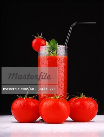 Fresh tomatoes and a glass full of tomato juice