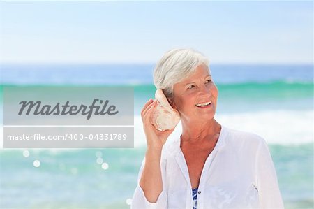 Mature woman listening to her shell