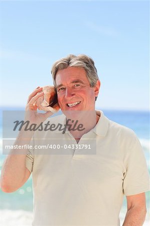 Senior man listening to his shell