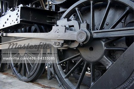 Closeup of vintage steem engine's black, iron wheel