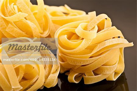 Italian raw pasta on a black plate