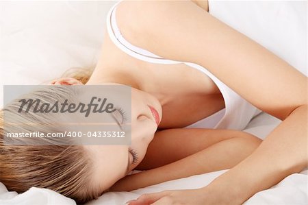 Cute young woman sleeping on the bed in casual clothes