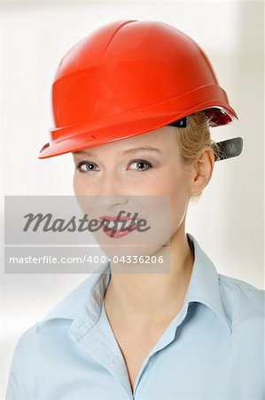 Young female engineer in red helmet