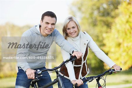 Attractive couple on bicycles in the park