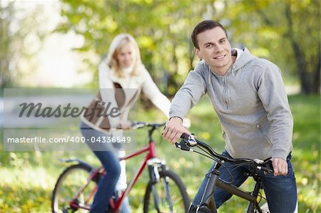 A man on a bicycle in the park in the foreground