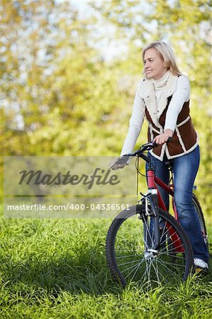 A young girl on a bicycle in the autumn park