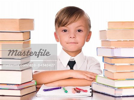 Six year old boy surrounded by piles of books isolated against a white background