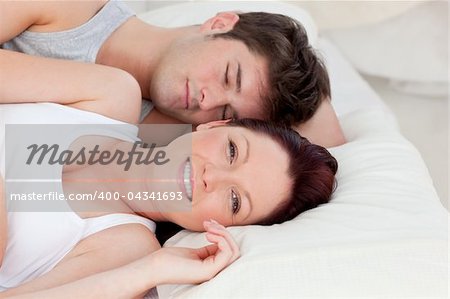 Lovely young couple resting in bed together in the bedroom
