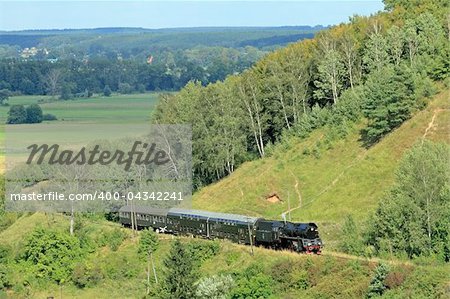 Beautiful hilly landscape with an old retro steam train
