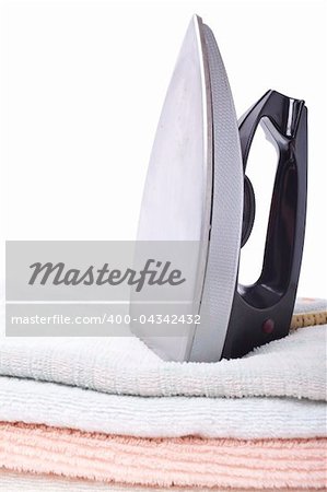 Modern electric iron and towel on white background