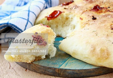 Italian Focaccia bread with tomatoes on a cutting board