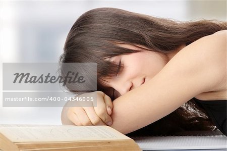 Sleeping while learning - tired teen woman sleeping on desk