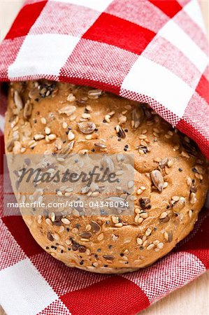 Whole wheat loaf in a red and white cloth ready to be served