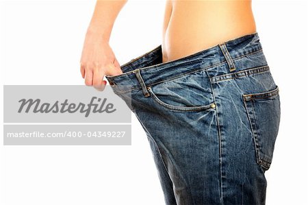 A picture of a young slim woman in oversized pair of blue jeans over white background