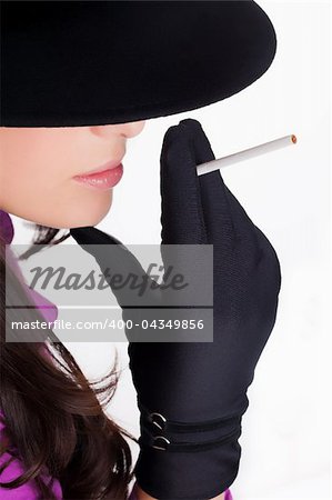 Portrait of a beautiful brunette young woman with black hat,gloves and cigar