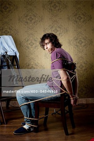 An image of a young man tied on a chair